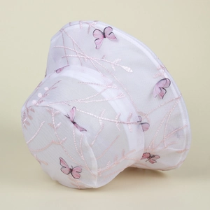 Détail d'un chapeau bob en résille avec broderie délicate de papillons roses et branches