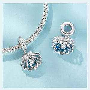 Détail d'un pendentif coquillage en argent S925 avec perle et pierre bleue