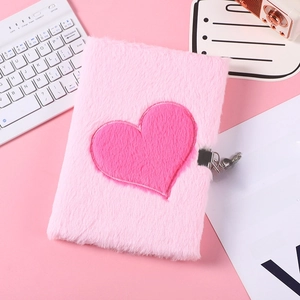 Detail of pink plush notebook with heart design and silver metal lock on pink background