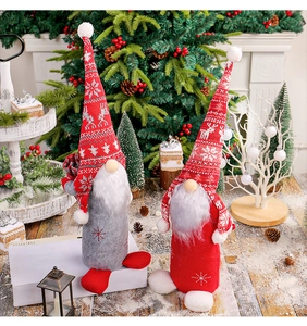 Détail de gnomes de Noël rouges et gris avec chapeaux tricotés posés sur une cheminée