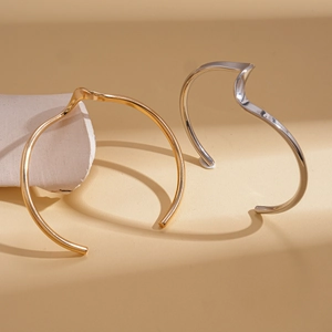Minimalist irregular geometric twisted metal open bangle in gold and silver finish