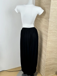 Detail of high-waist black pleated tulip skirt paired with a white slim t-shirt