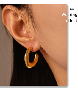 Macro view of minimalist C-shape irregular gold-plated earrings shown on a model