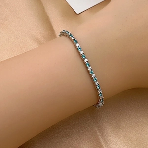 Detail shot of a tennis bracelet with sparkling white and turquoise zirconia stones