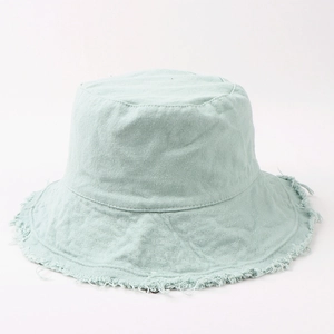 Detailed close-up of frayed edges and textured cotton fabric on a mint green bucket hat