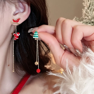Close-up of asymmetrical Christmas tassel earrings featuring Santa, sled and tree icons