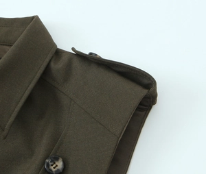Détail de l'épaulette avec bouton en résine sur une robe courte vert militaire