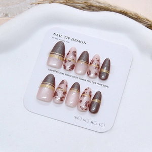 Handmade brown cat eye fake nails with leopard print and gold lines on display
