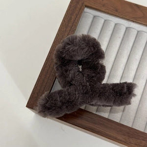 Detail of soft dark brown plush hair claw clip with a fluffy texture for winter hairstyles