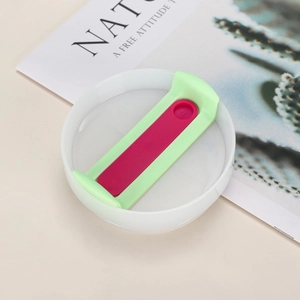 Detailed view of white 40oz tumbler lid with green handle and red sliding switch