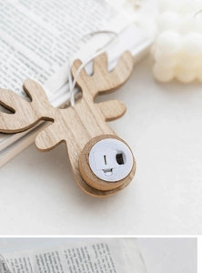 Detail of wooden reindeer ornament back showing the battery compartment and power switch