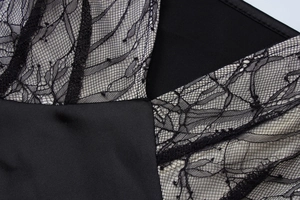 Detailed view of black floral lace stitching with beige lining on a bodycon dress