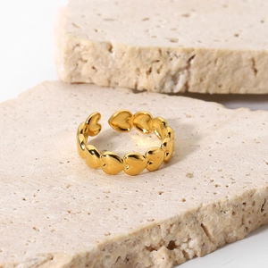 Gros plan détaillé d'une bague ouverte en acier doré avec des motifs de cœurs reliés