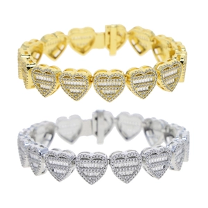 Detailed macro view of gold and silver heart-shaped bracelets with cubic zirconia stones