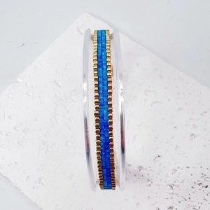 Close-up of handmade blue and gold Miyuki beadwork texture on adjustable bracelet