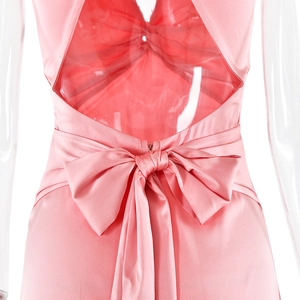 Détail du dos d'une robe en satin rose avec un grand noeud et un design dos nu