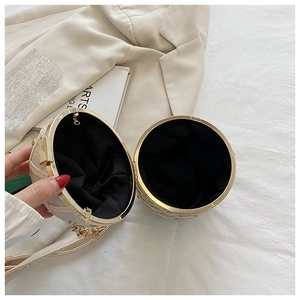 Detailed view of white round evening bag with gold rivets and metallic chain strap