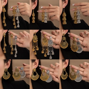 Detail of bohemian tassel earrings with intricate metal carving and bell charms