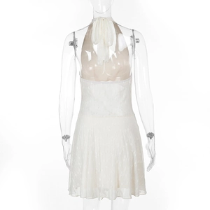 Close-up of white lace backless dress showing halter tie straps and floral lace texture