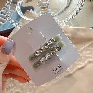 Detail of rectangular hair clips with sparkling heart crystals on a display card