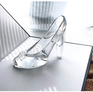 Détail macro d'un escarpin en cristal transparent avec nœud ciselé sur socle blanc