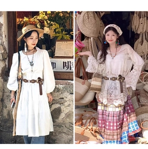 Dettaglio di cintura in pelle vintage bohémien con incisioni floreali su abito bianco