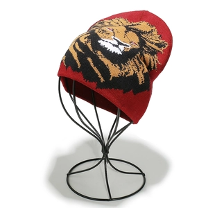 Detailed close-up of a red knitted beanie featuring a lion jacquard pattern for winter