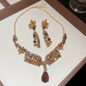 Detail of floral jewelry set with amber gemstones and red drop pendant in display box