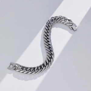 Vista dettagliata di un bracciale a maglia cubana argento con finitura metallica lucida