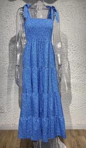 Detail view of smocked bodice and tiered hem on blue floral backless maxi dress