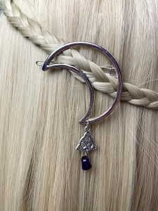 Detail of silver crescent moon hair clip with purple stone bead and Celtic knot on braided hair