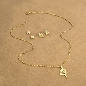 Detailed view of hollow rose pendant necklace and matching gold-plated stud earrings