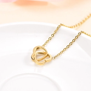 Minimalist gold-plated double heart pendant necklace with thin chain on white tray