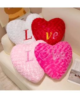 Macro detail of plush heart cushions with Love embroidery in various soft colors