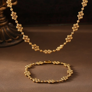 Elegant gold beaded flower necklace and bracelet jewelry set in minimalist geometric style