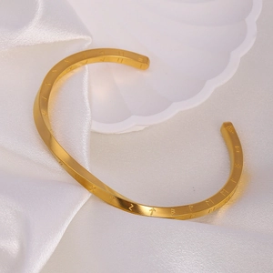 Macro shot of gold Mobius cuff bracelet featuring Nordic Viking runes on white silk
