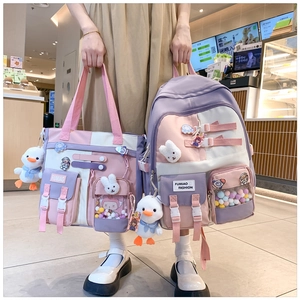 Detail view of pink and purple school backpack set with cute pins and duck pendant