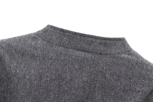Makro-Detailansicht der grauen Tweedjacke mit Wolltextur und Stehkragen-Design
