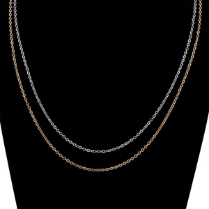 Close-up of polished silver and rose gold stainless steel link chains on black background