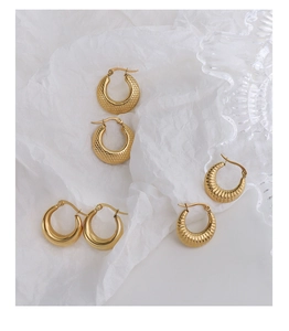 Trois paires de créoles dorées aux textures lisse, quadrillée et de style croissant