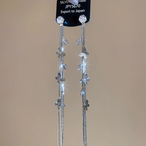 Détail macro de boucles d'oreilles pampilles en argent avec papillons et zircons