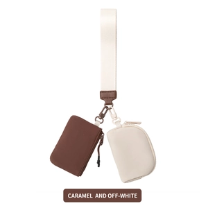 Detail of caramel and off-white nylon wrist pouches with durable strap and leather accents