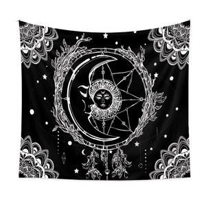 Detail of bohemian black and white tapestry showing moon, sun and mandala art patterns