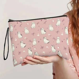 Trousse de maquillage rose aux motifs de chats avec fermeture éclair tenue à la main