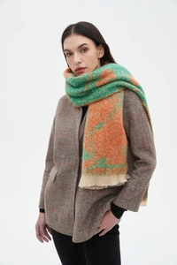 Close-up of green and orange floral jacquard scarf with soft tassel fringe detail