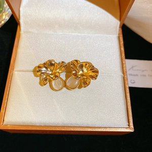 Detail view of vintage golden flower earrings with white pearls in an orange jewelry box