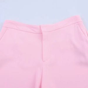 Detailed view of pink trousers waist featuring concealed closure and smooth fabric