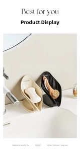 Macro shot of leaf-shaped drainage soap holders in cream and black for modern bathroom