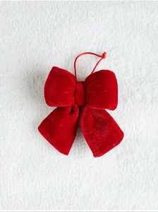 Close-up of a festive red velvet Christmas bow pendant with a matching hanging string