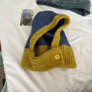 Detail of yellow and blue knitted balaclava with chunky yarn and button closure